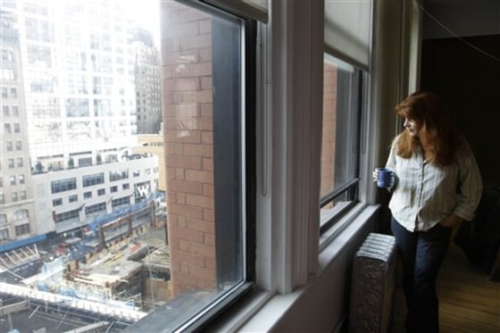 Mary Perillo looks from her apartment window at the deconstruction of the former Deutsche Bank, lower left, on Wednesday in New York. Nearly a decade after the attacks of Sept. 11, 2001, the oft-delayed deconstruction of the former Deutsche Bank building at ground zero is finally almost complete. 